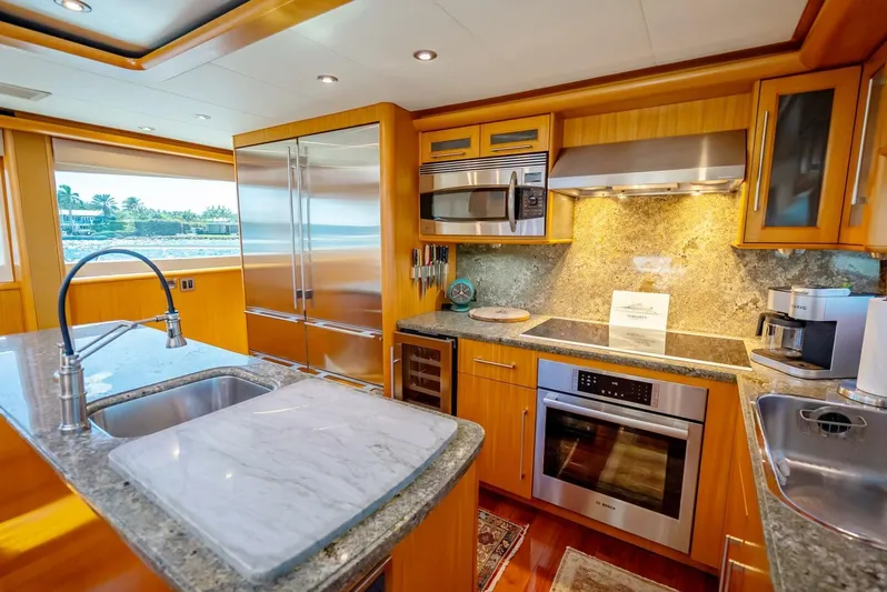 Serenity Yacht Photos Pics Luxurious kitchen in a 2008 Lazzara Motor Yacht with modern appliances and marble countertops.
