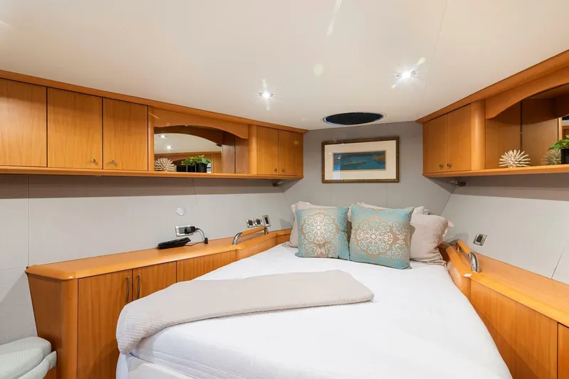 Serenity Yacht Photos Pics Luxurious bedroom interior of 2008 Lazzara Motor Yacht with wooden cabinets and cozy bedding.