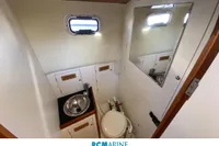 Compact bathroom in 2008 Rhea 800 boat with sink, toilet, and mirror.