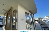 2008 Rhea 800 boat exterior with windows and railing under clear blue sky.