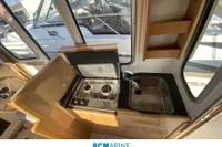 Compact kitchen area in a 2008 Rhea RHEA 800 boat with stove and sink.