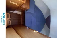 Interior of 2008 Rhea RHEA 800 boat with wooden furnishings and blue seating.