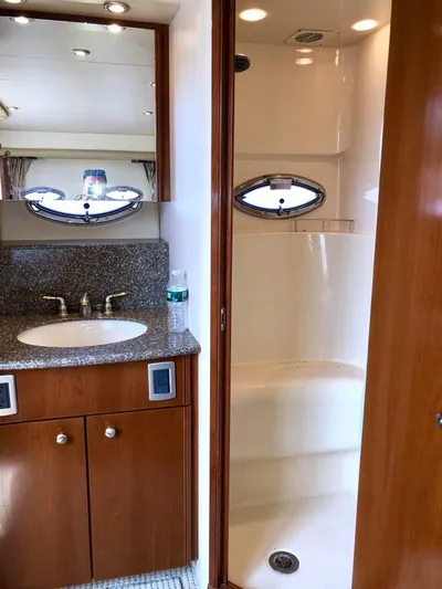  Yacht Photos Pics 2005 Meridian 459 Motoryacht bathroom with sink, shower, and wooden cabinetry.