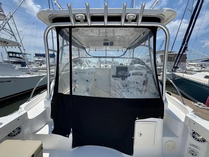 Bilboat Baggins Yacht Photos Pics 2011 Boston Whaler 305 Conquest boat with clear enclosure, docked at marina.