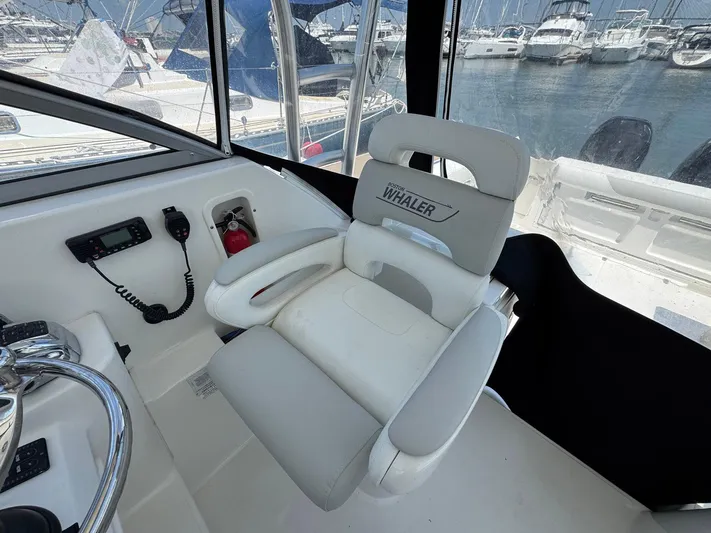Bilboat Baggins Yacht Photos Pics Captain's seat on 2011 Boston Whaler 305 Conquest, overlooking marina with boats.