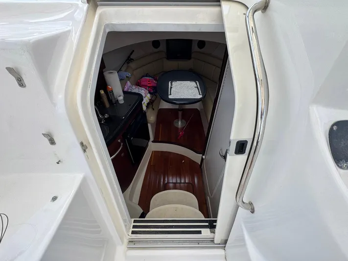 Bilboat Baggins Yacht Photos Pics 2011 Boston Whaler 305 Conquest cabin interior with table and seating area.