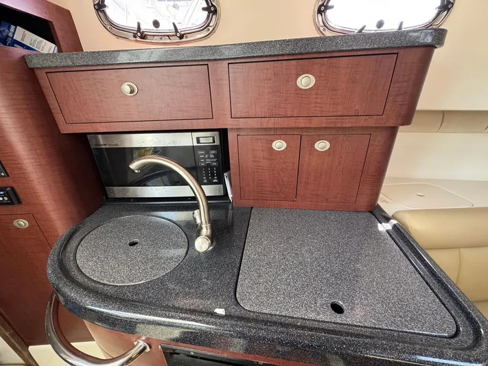 Bilboat Baggins Yacht Photos Pics 2011 Boston Whaler 305 Conquest galley with sink, microwave, and storage cabinets.