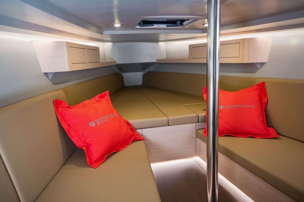 Interior of 2026 Saffier SE 33 Life yacht with beige seating and red cushions.
