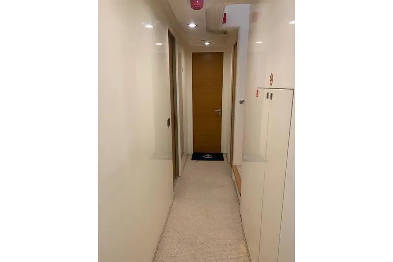  Yacht Photos Pics Narrow hallway inside 2012 Huzur Yachts 78, featuring sleek design and wooden door.