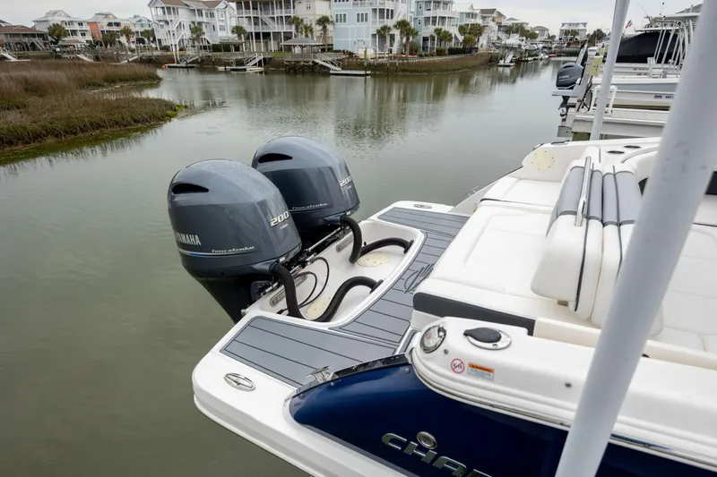  Yacht Photos Pics 2023 Chaparral 280 OSX boat with dual outboard engines docked in a scenic marina.