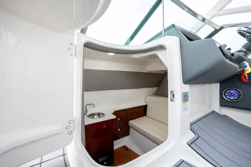  Yacht Photos Pics 2023 Chaparral 280 OSX cabin interior with sink and seating area.