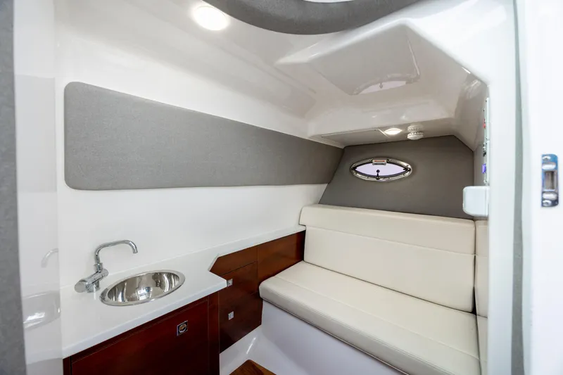  Yacht Photos Pics 2023 Chaparral 280 OSX cabin interior with sink and seating area.