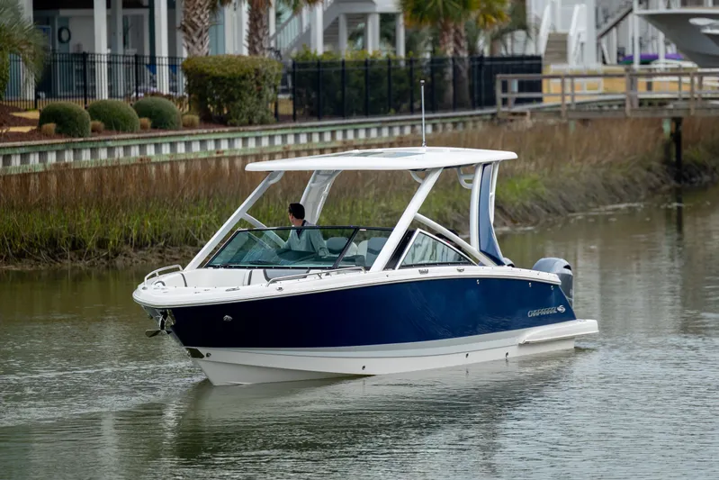  Yacht Photos Pics 2023 Chaparral 280 OSX boat cruising on a calm waterway.