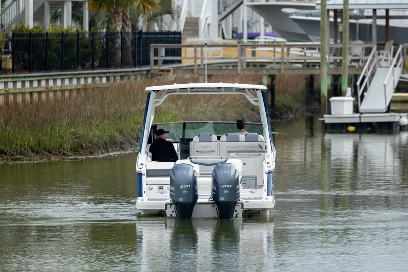  Yacht Photos Pics 2023 Chaparral 280 OSX boat cruising in a calm waterway.
