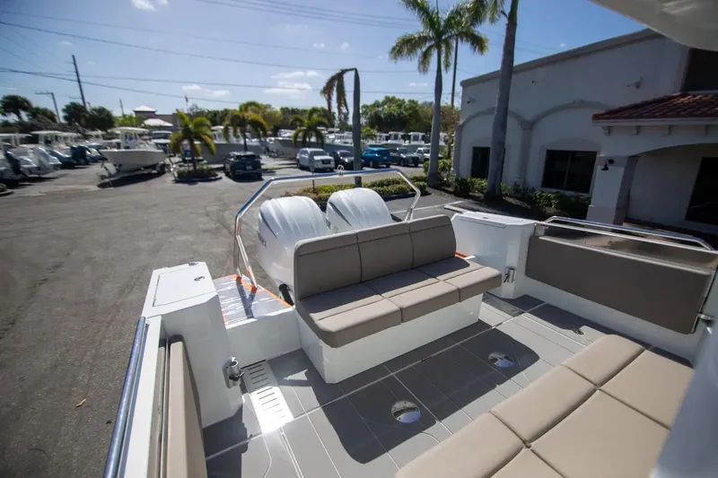  Yacht Photos Pics 2025 Quarken 35 Cabin boat with spacious seating, parked outdoors under palm trees.