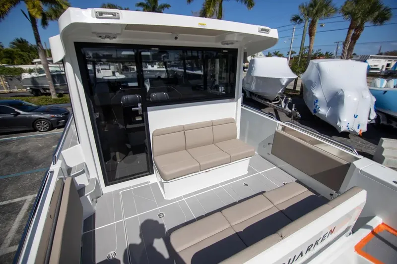  Yacht Photos Pics 2025 Quarken 35 Cabin boat with spacious seating and modern design in a sunny marina.