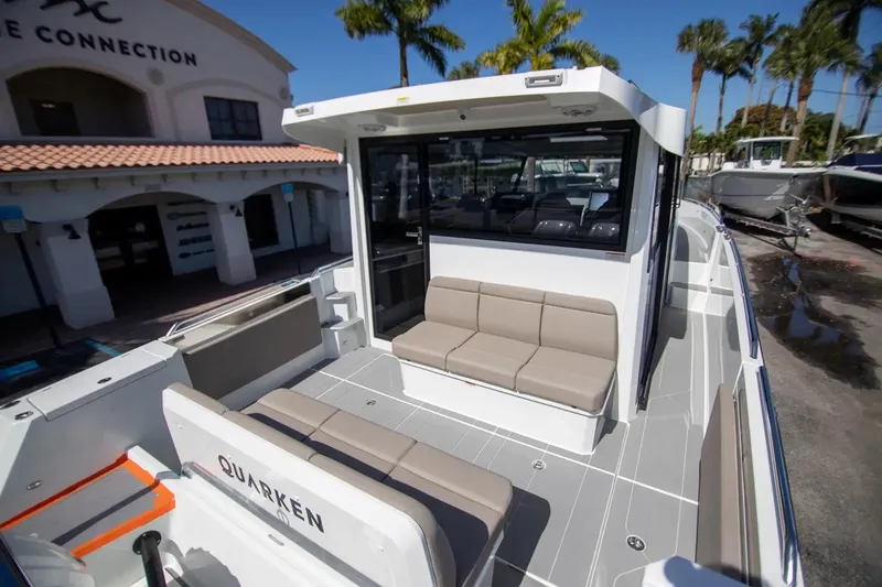  Yacht Photos Pics 2025 Quarken 35 Cabin boat with modern seating, docked near palm trees.