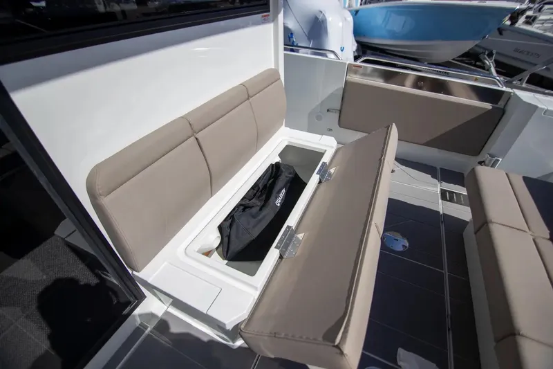  Yacht Photos Pics 2025 Quarken 35 Cabin boat with open storage compartment under cushioned seating.