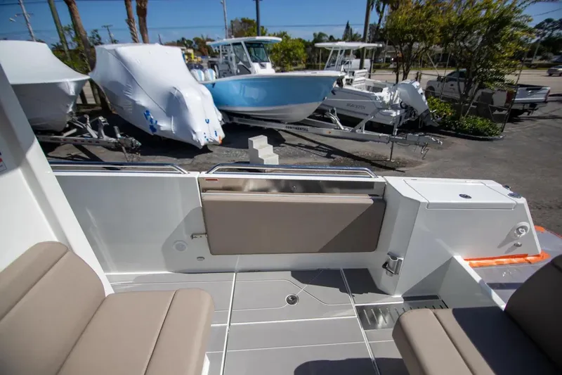  Yacht Photos Pics 2025 Quarken 35 Cabin interior with beige seating, docked boats in the background.