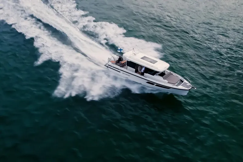  Yacht Photos Pics 2025 Quarken 35 Cabin boat cruising swiftly on open water.