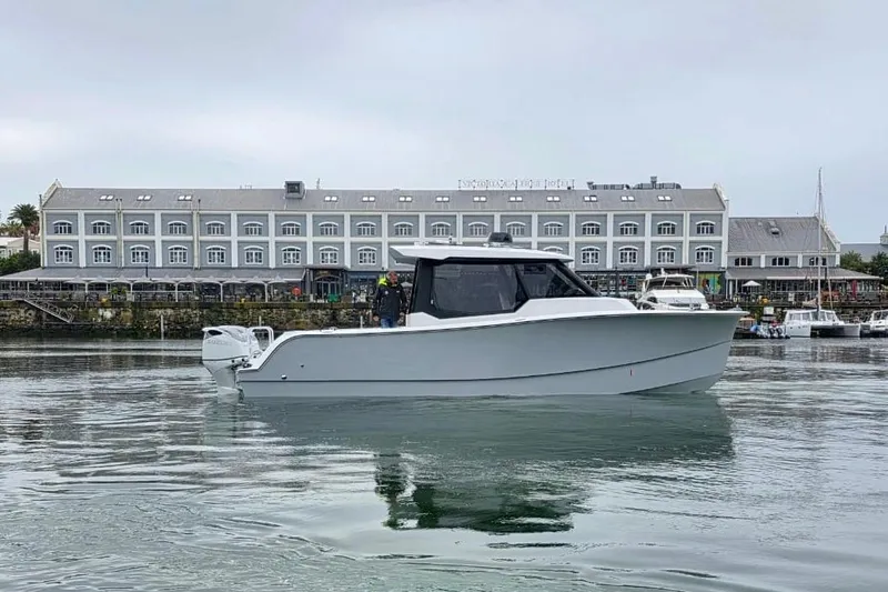 Hammercat 35hh Yacht Photos Pics 2026 Hammer Yachts 35HH cruising in a marina, with a hotel in the background.