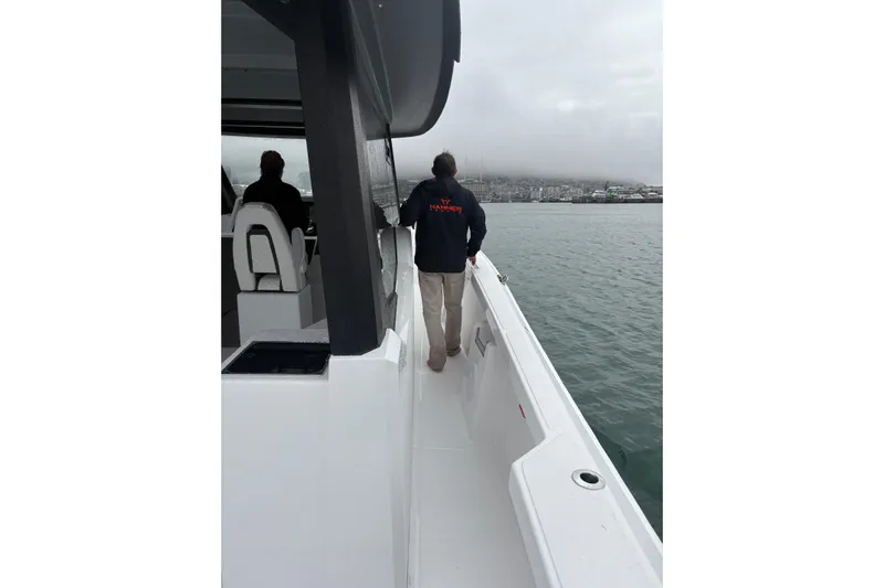 Hammercat 35hh Yacht Photos Pics Person walking on deck of 2026 Hammer Yachts 35HH, overlooking calm waters.