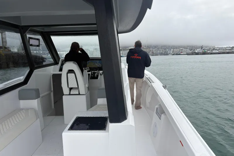 Hammercat 35hh Yacht Photos Pics 2026 Hammer Yachts 35HH boat interior with two people navigating in a harbor.