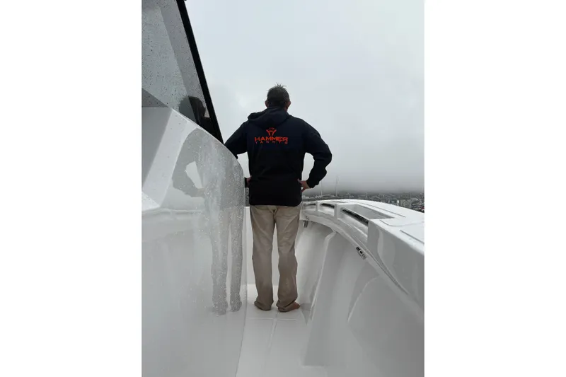 Hammercat 35hh Yacht Photos Pics Man standing on Hammer Yachts 35HH, 2026 model, overlooking cloudy seascape.
