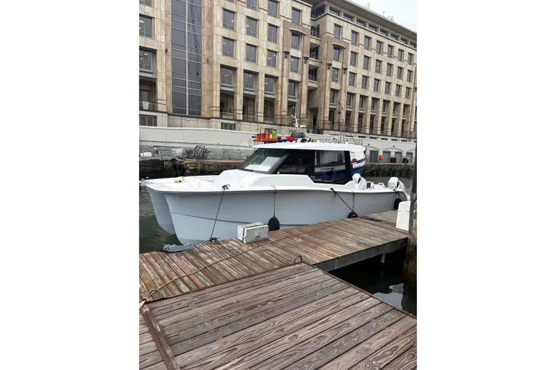 Hammercat 35hh Yacht Photos Pics 2026 Hammer Yachts 35HH docked by a wooden pier, urban backdrop.