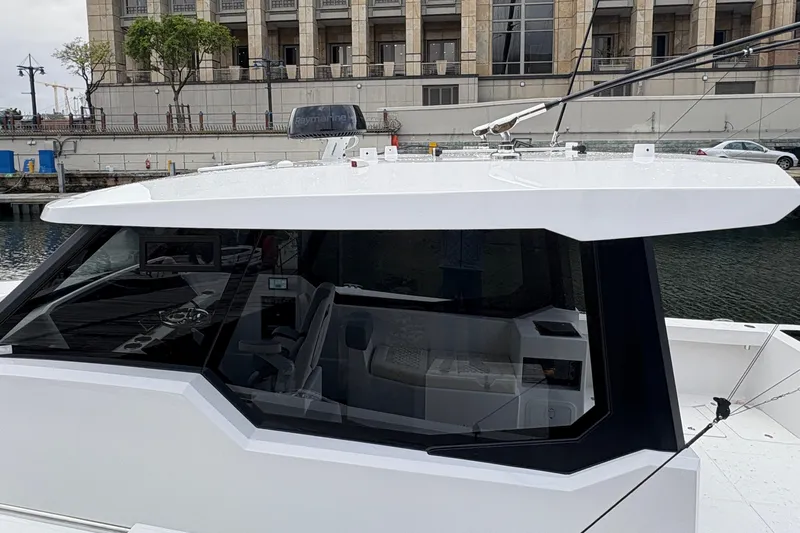 Hammercat 35hh Yacht Photos Pics 2026 Hammer Yachts 35HH boat with sleek design docked by waterfront building.