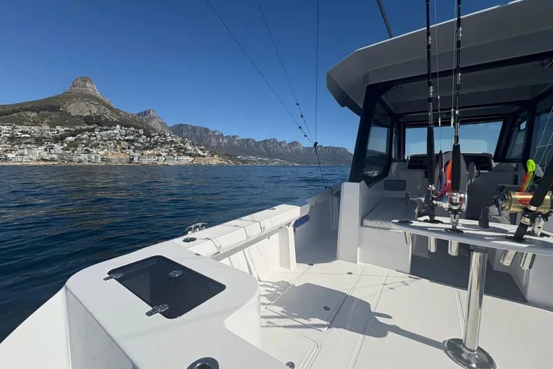 Hammercat 35hh Yacht Photos Pics 2026 Hammer Yachts 35HH on scenic water with fishing gear and mountain backdrop.