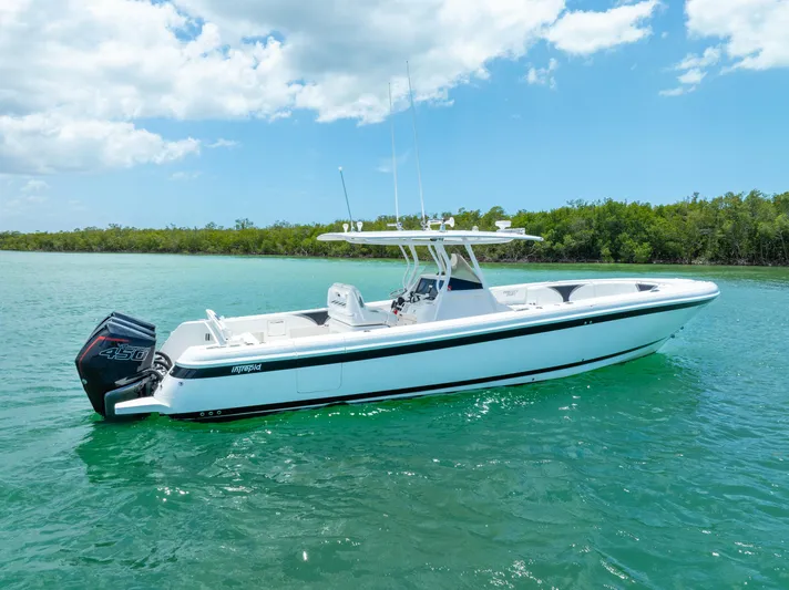 Freaky Fast Yacht Photos Pics 2018 Intrepid 375 Open boat on turquoise water under a partly cloudy sky.
