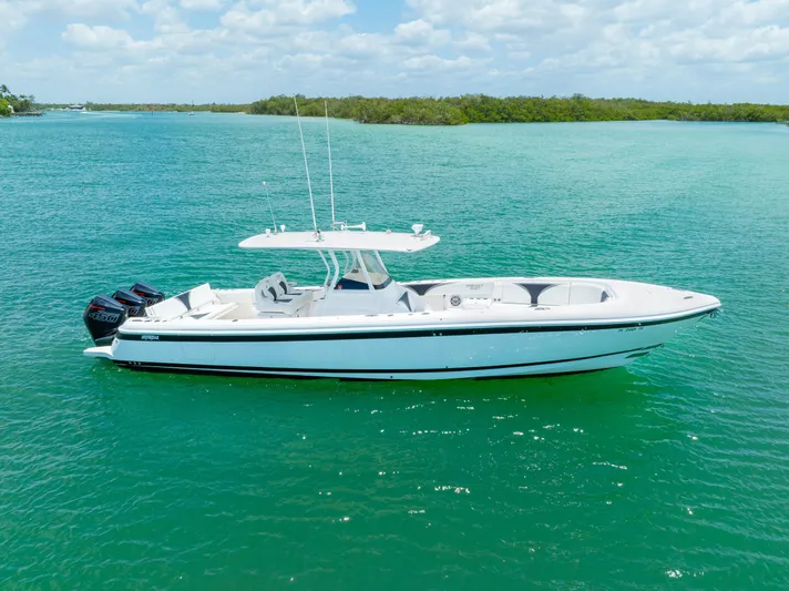 Freaky Fast Yacht Photos Pics 2018 Intrepid 375 Open boat on clear turquoise water under a partly cloudy sky.