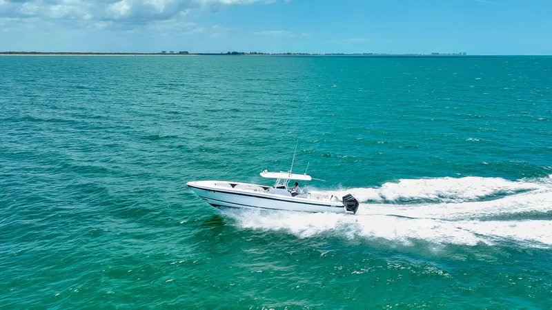 Freaky Fast Yacht Photos Pics 2018 Intrepid 375 Open boat cruising on turquoise ocean waters under a partly cloudy sky.