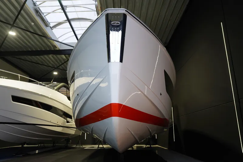  Yacht Photos Pics 2025 Schaefer V44 yacht in showroom, sleek design with red accent stripe.