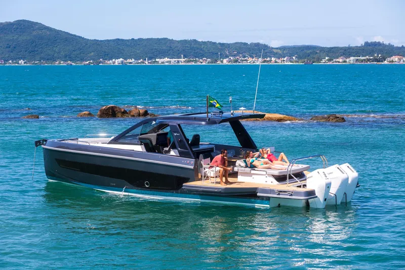  Yacht Photos Pics 2025 Schaefer V44 yacht cruising on turquoise waters near scenic coastline.