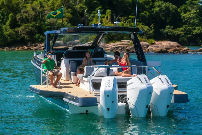  Yacht Photos Pics 2025 Schaefer V44 yacht cruising with passengers, featuring triple Mercury outboard engines.