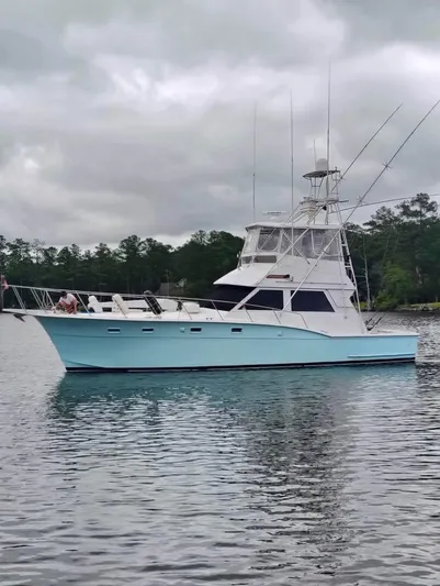 Shameless Yacht Photos Pics 1983 Hatteras 46 Convertible yacht on calm water under cloudy skies.