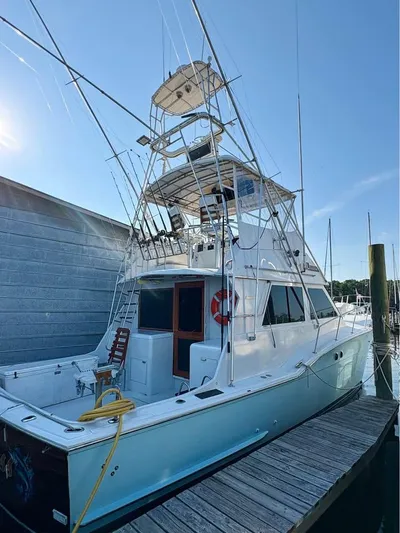 Shameless Yacht Photos Pics 1983 Hatteras 46 Convertible yacht docked at marina under clear blue sky.