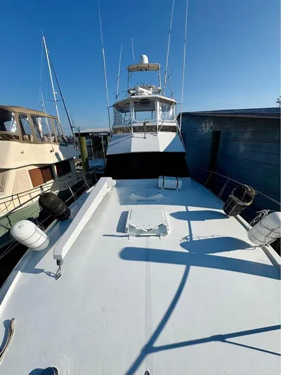 Shameless Yacht Photos Pics 1983 Hatteras 46 Convertible yacht docked, showcasing spacious deck and sleek design.