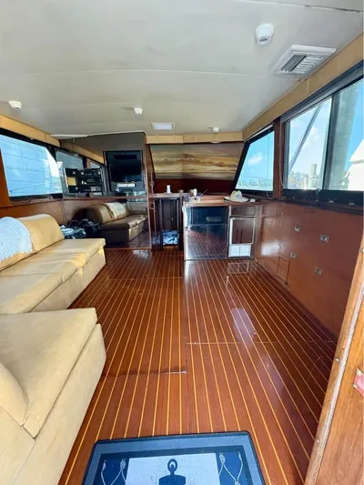 Shameless Yacht Photos Pics Interior of 1983 Hatteras 46 Convertible yacht with wooden flooring and beige seating.