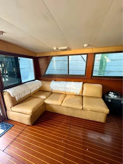Shameless Yacht Photos Pics Interior of 1983 Hatteras 46 Convertible yacht with beige leather seating and wooden flooring.