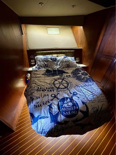 Shameless Yacht Photos Pics Luxurious cabin interior of 1983 Hatteras 46 Convertible yacht with nautical-themed bedding.