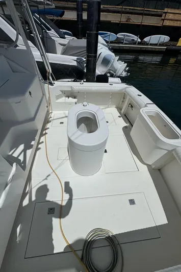 No Problem Yacht Photos Pics 1998 Cabo 35 Express boat deck with fishing equipment at marina.