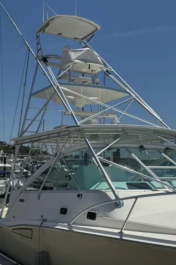 No Problem Yacht Photos Pics 1998 Cabo 35 Express boat with tower, docked under clear blue sky.