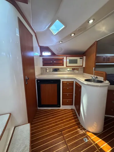 No Problem Yacht Photos Pics 1998 Cabo 35 Express yacht interior with kitchenette, wood cabinets, and modern appliances.