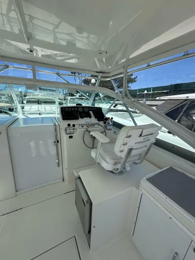 No Problem Yacht Photos Pics 1998 Cabo 35 Express boat helm with captain's chair and control panel.