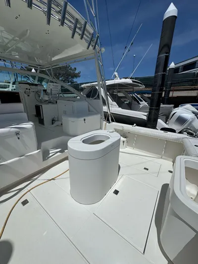 No Problem Yacht Photos Pics 1998 Cabo 35 Express boat deck with seating and storage, docked at marina.