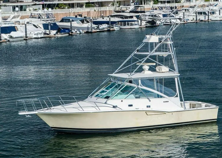 No Problem Yacht Photos Pics 1998 Cabo 35 Express boat docked in marina, surrounded by other vessels.