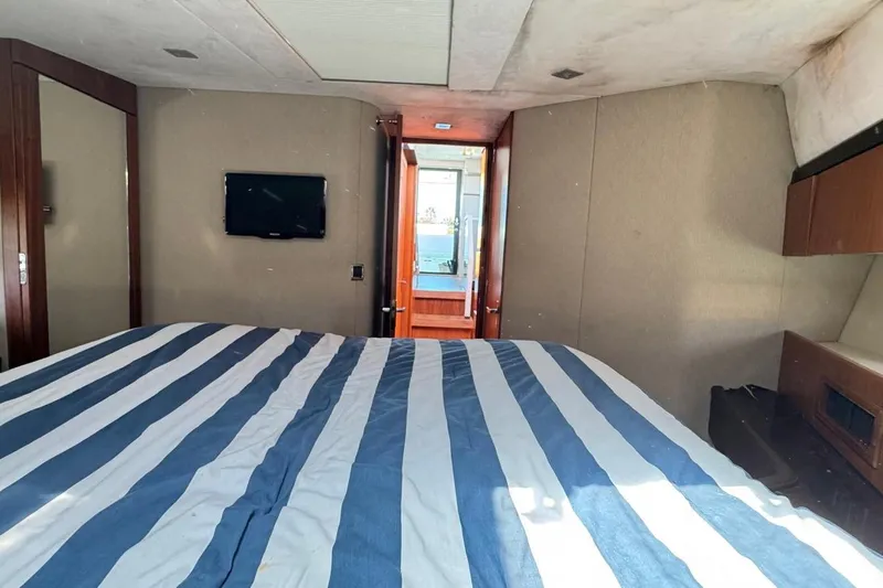  Yacht Photos Pics Interior of 2013 Fairline Squadron 42 yacht with striped bedding and wall-mounted TV.